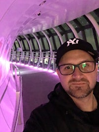 a man taking a selfie in a tunnel with purple lights