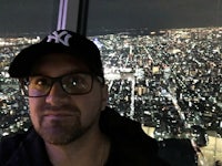 a man standing at the top of a building at night