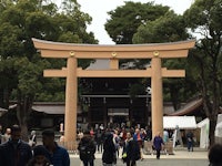 a group of people standing in front of a tori gate