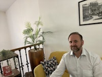 a man sitting on a yellow chair in a living room