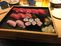 a tray of sushi on a wooden table