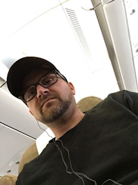 a man sitting on an airplane with headphones on